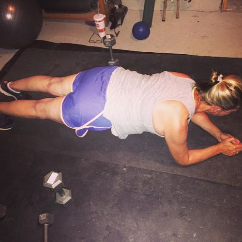 Client planking in her garage gym