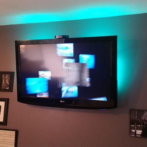 A 37"TV on a tilt mount in a bedroom with LED back