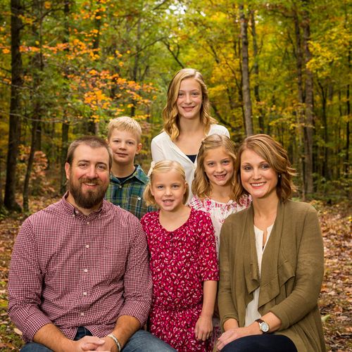 Fall family portrait with a wooded background