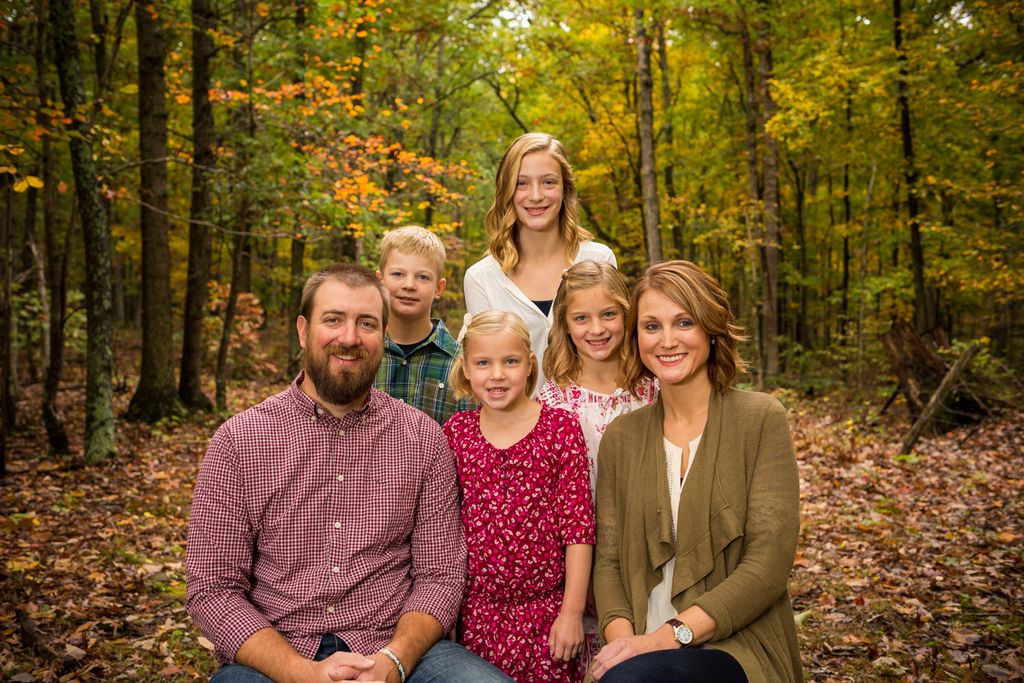 Fall family portrait with a wooded background
