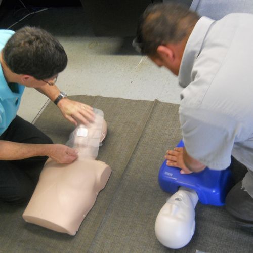 One employee about to give Rescue Breaths, while a