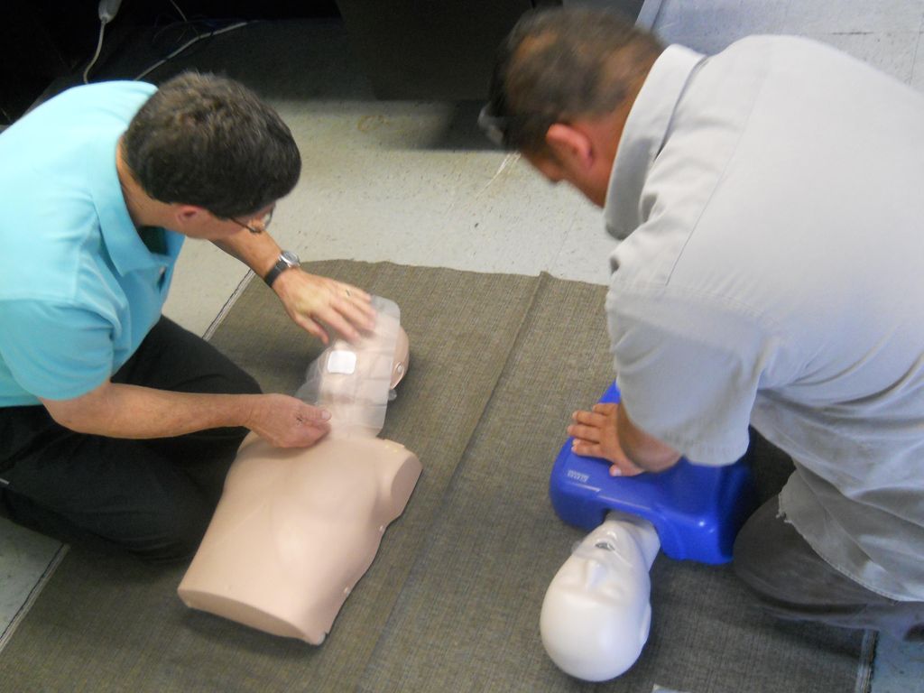 One employee about to give Rescue Breaths, while a