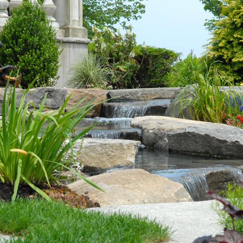 Natural stone water feature set into garden along 