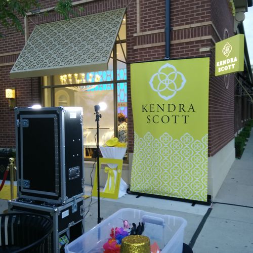 Outdoor photo booth setup with custom backdrop and