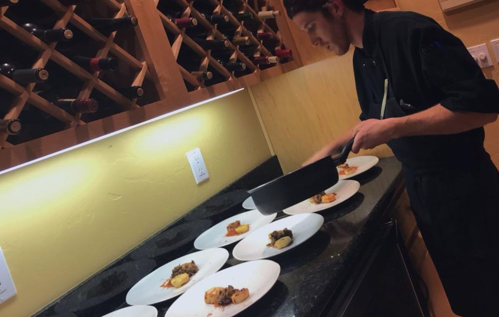 Chef Matthew plating seared scallops and Duck conf