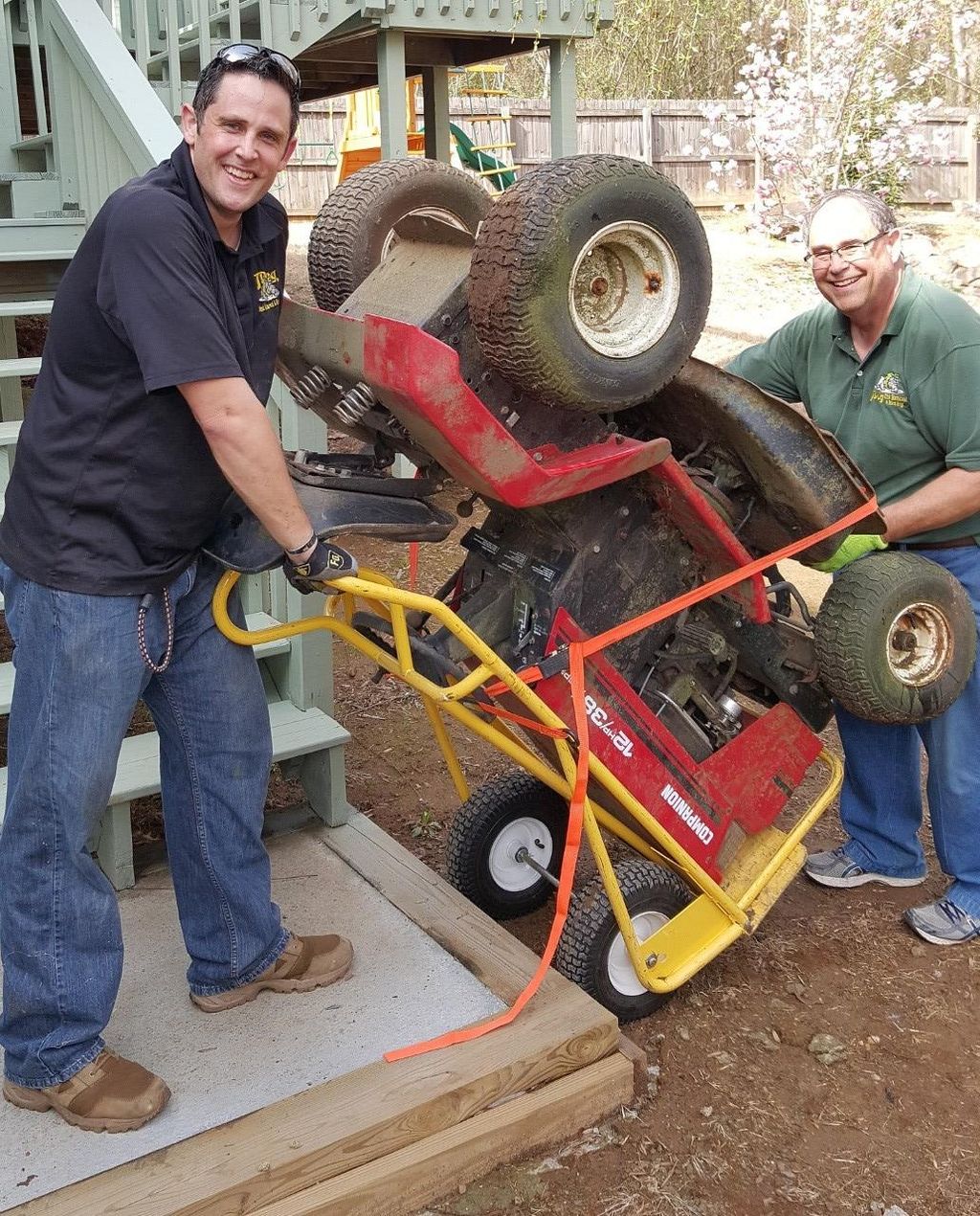 My dad and I hauling off a broken riding lawn mowe