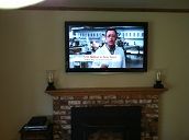 Mounted TV above the fireplace on an exterior wall