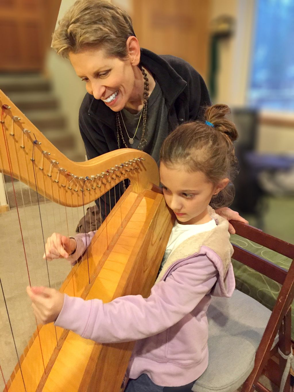 Anne Roos teaching harp lessons to 7-year-old stud