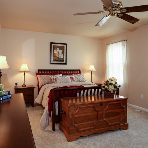 Master bedroom staged with homeowners furnishings