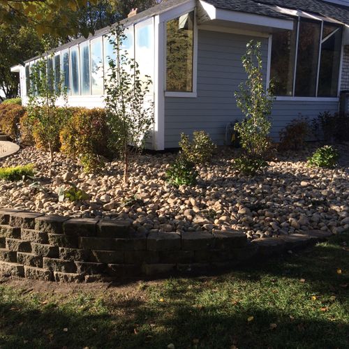 Retaining wall, river rock, and plantings for curb