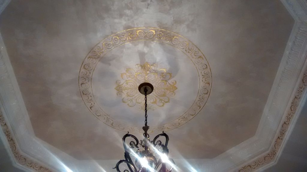 Plaster work with gold medallion. Crown molding pa