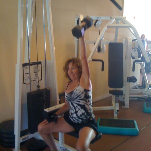 Barb doing one-armed seated overhead  presses at W