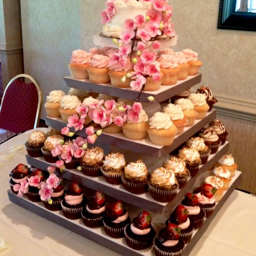 Wedding tower of various gourmet cupcakes with a C