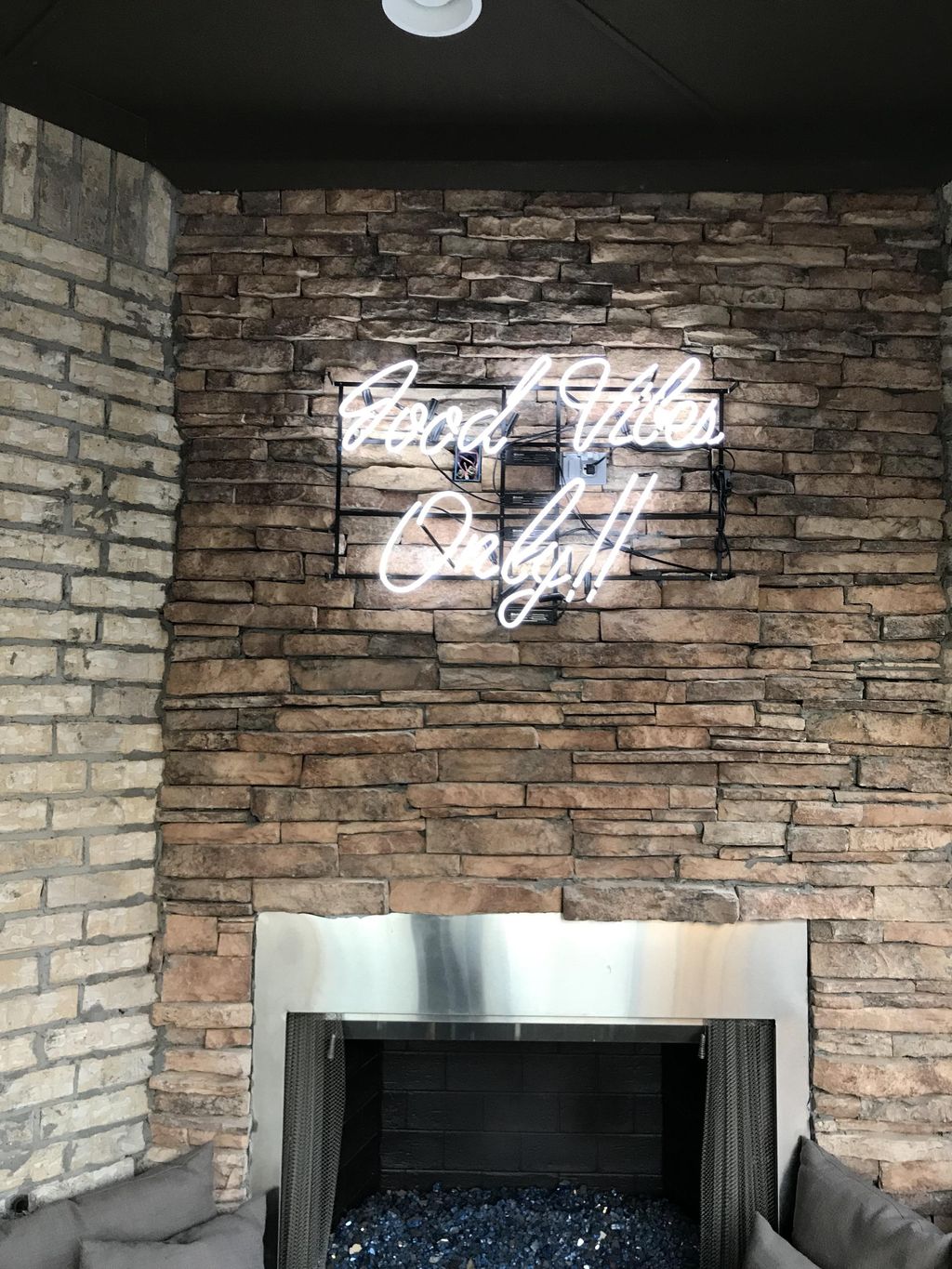 Install fluorescent sign above stone fireplace and