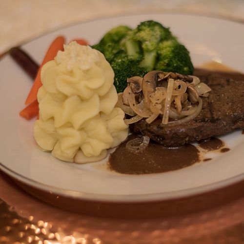 Steak with sauteed onions and mushrooms served wit
