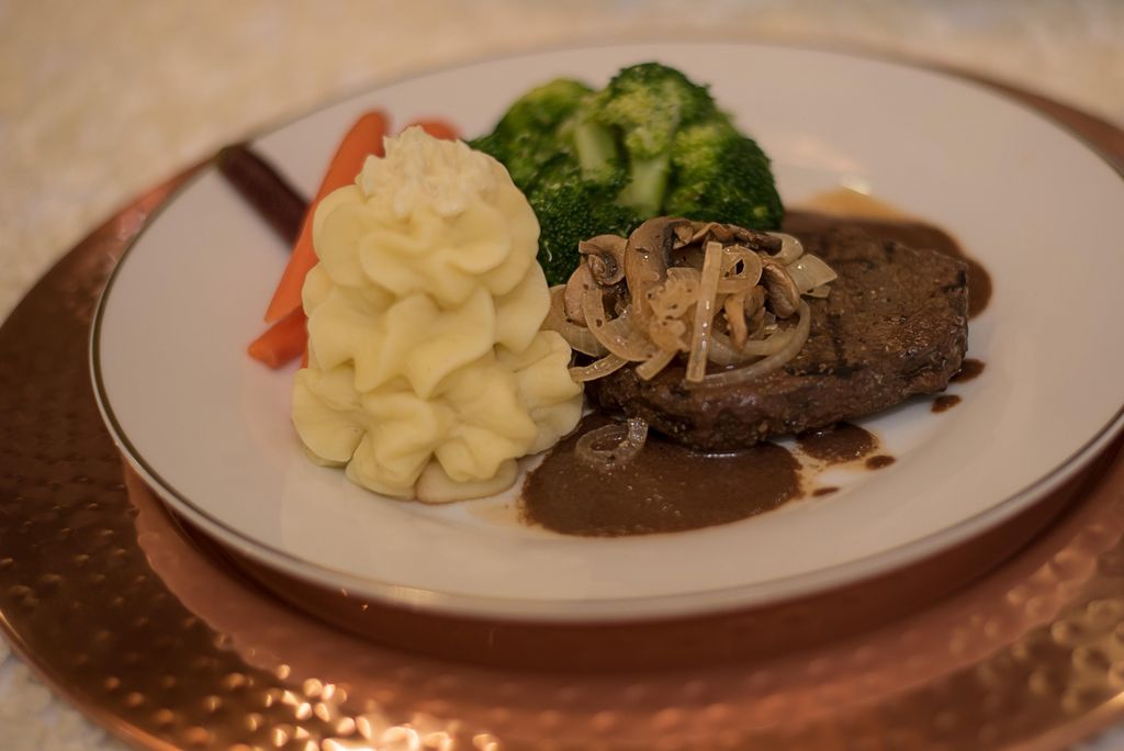 Steak with sauteed onions and mushrooms served wit