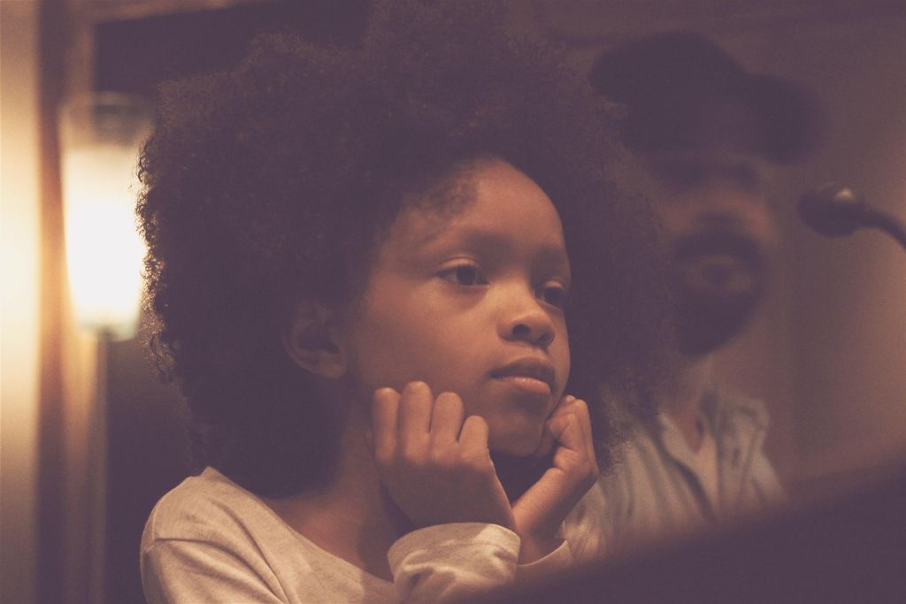 A young student hearing her original song play bac