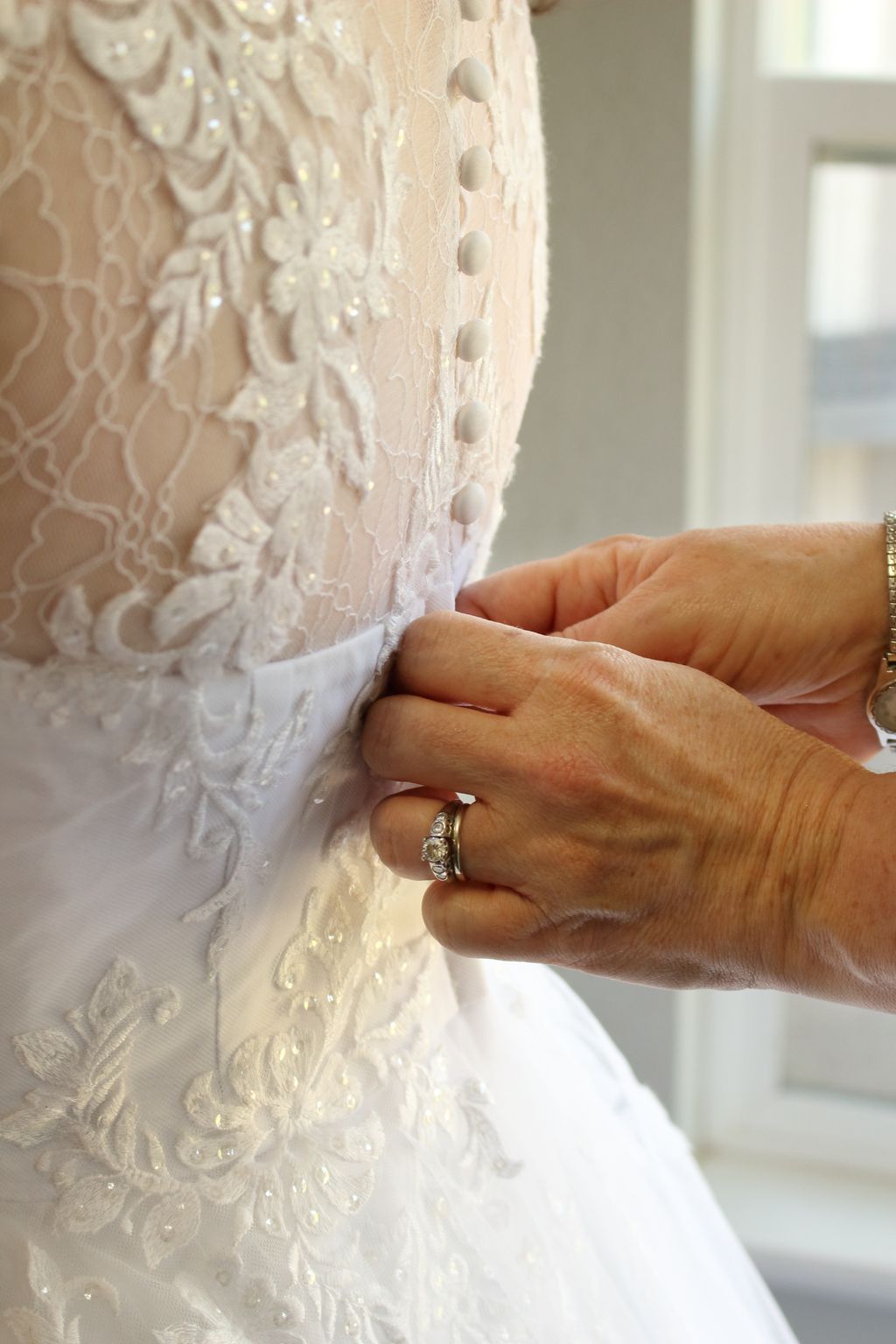Brides mother buttoning up her dress