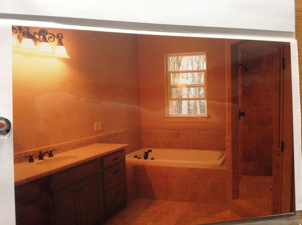 inset tub with single glass shower door on stall w