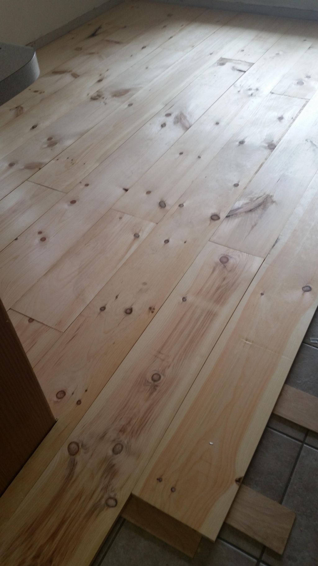 Installing wide pine flooring over concrete.