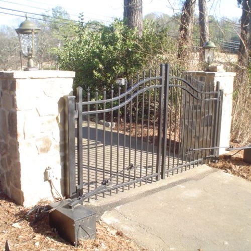 Wrought iron gate with rock cloumns and gate opera