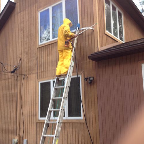 Power washing before staining house.
