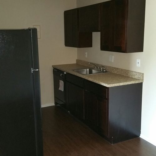 Kitchen cabinets, counter-top, sink,  and vinyl fl