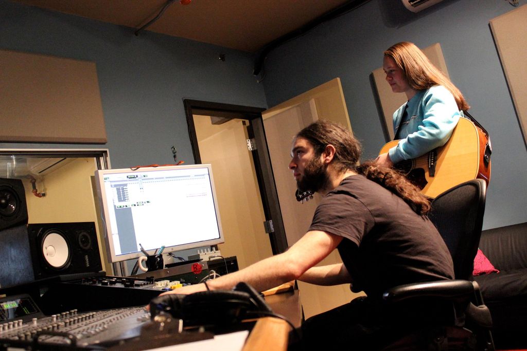 A teen student laying down some guitar parts.