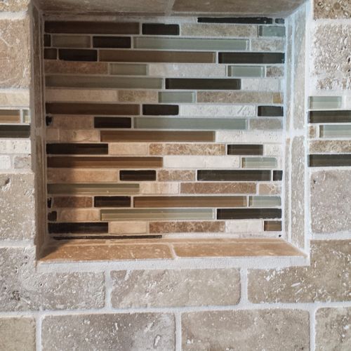 Shower shelf built into the wall.  Glass tile acce
