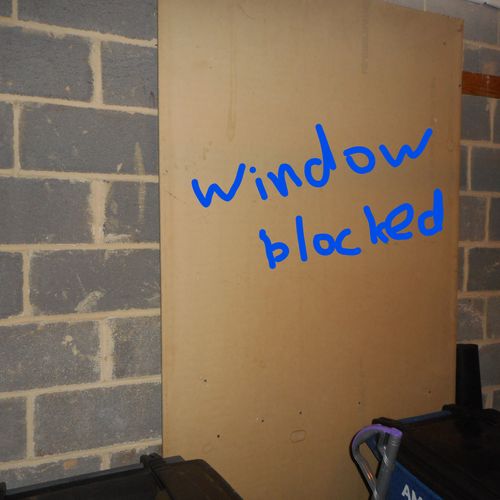 Window blocked by plywood due to rot.
