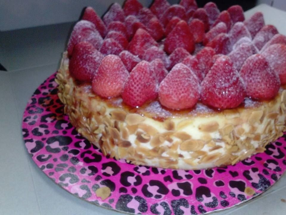 Cheesecake ontop of of spongecake almond slivers w