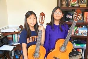 Siblings showing off their new guitars as they sta