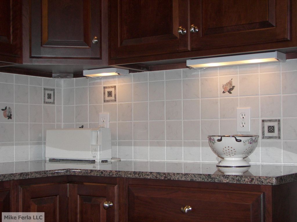 Kitchen back splash with accent pieces.