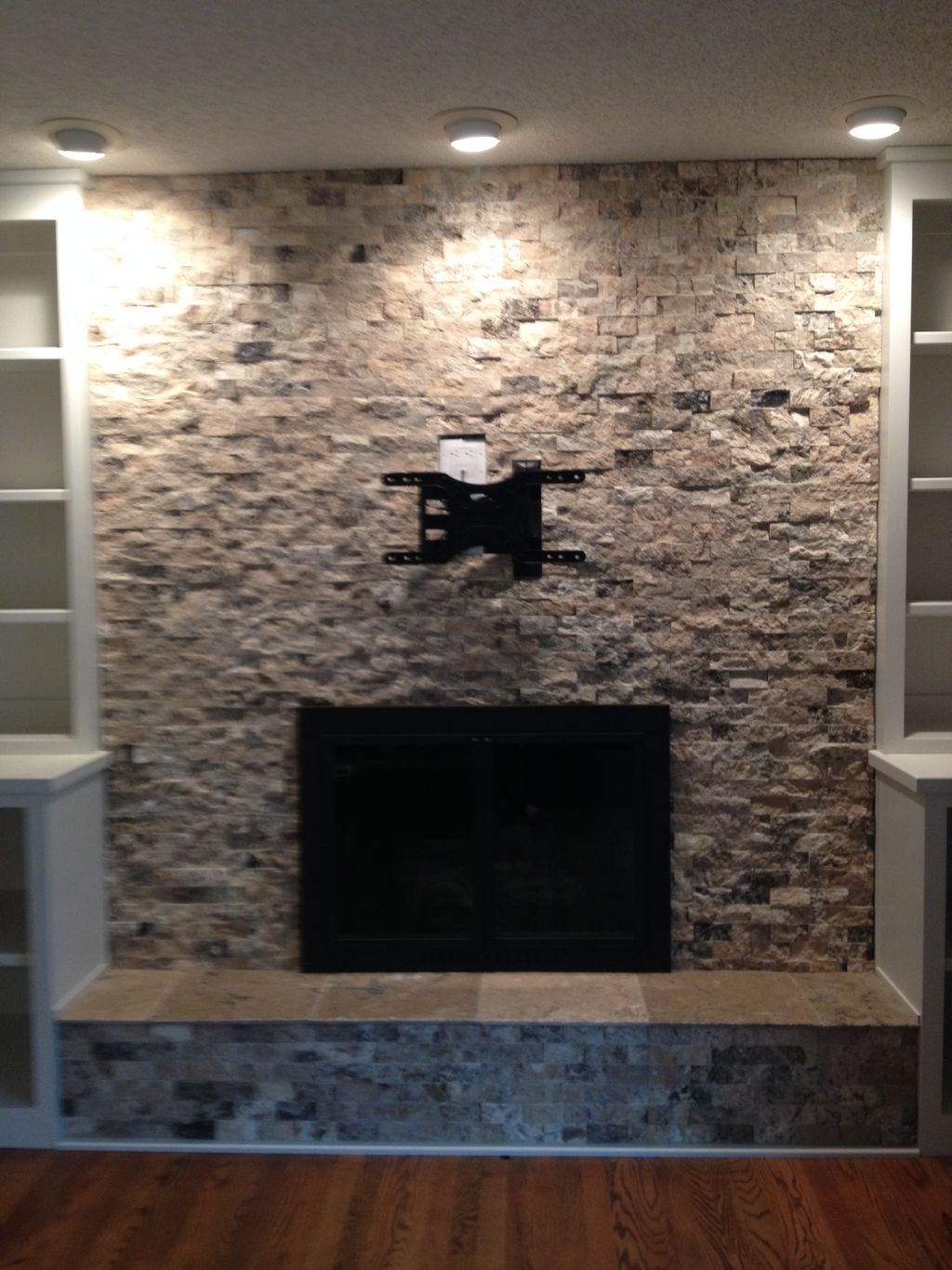 Split face stone tile refaced over brick fireplace