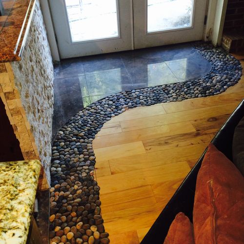 Custom flooring design with tile, pebbles and wood