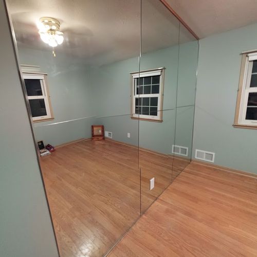 Floor to ceiling mirrors for an exercise room.
Loc