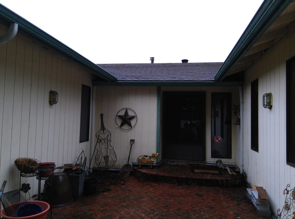 Gutters sloping toward house, clogged downspouts, 