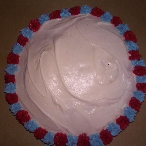 Round White Cake with white icing and blue and red