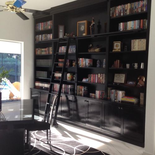 A wall unit with rolling ladder in black lacquer