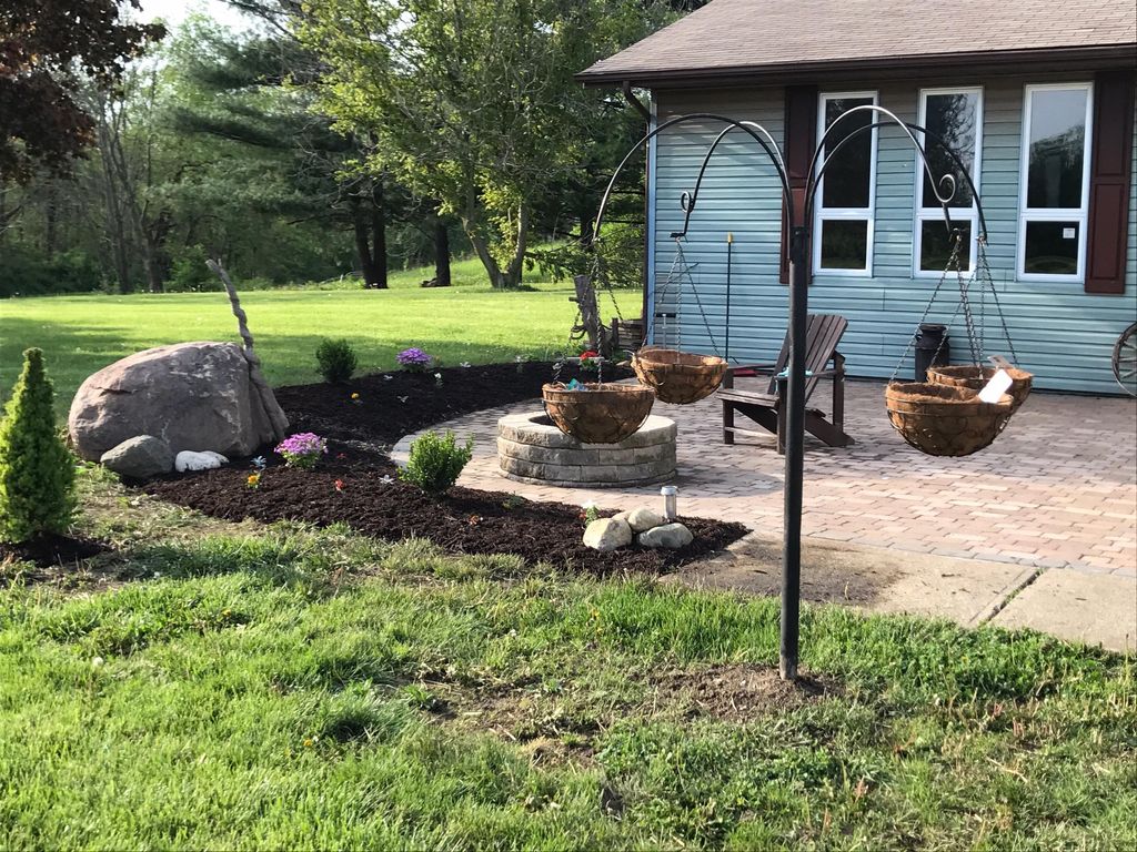 Fresh mulch, boulder placement, and new plants.