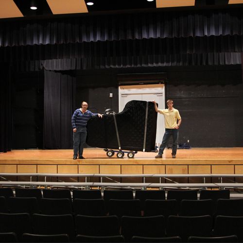 Moving a grand piano at a middle school.