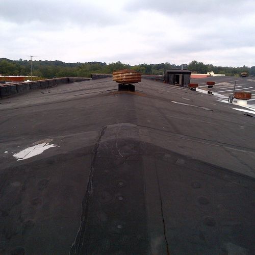 An old EPDM rubber roof with substantial leaks.