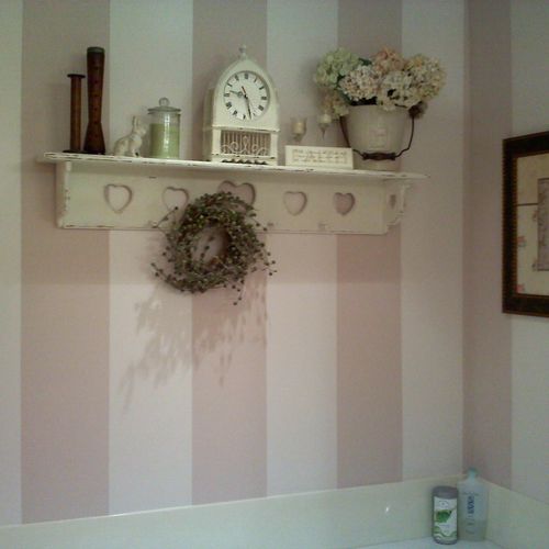 Soft pink striping around a bathtub adds a feminin