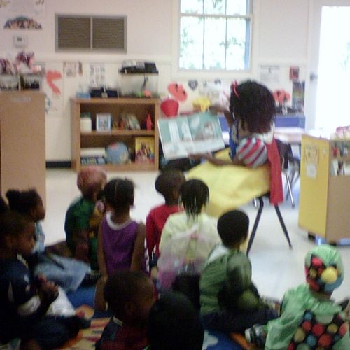 Snow White reads to a classroom of children.