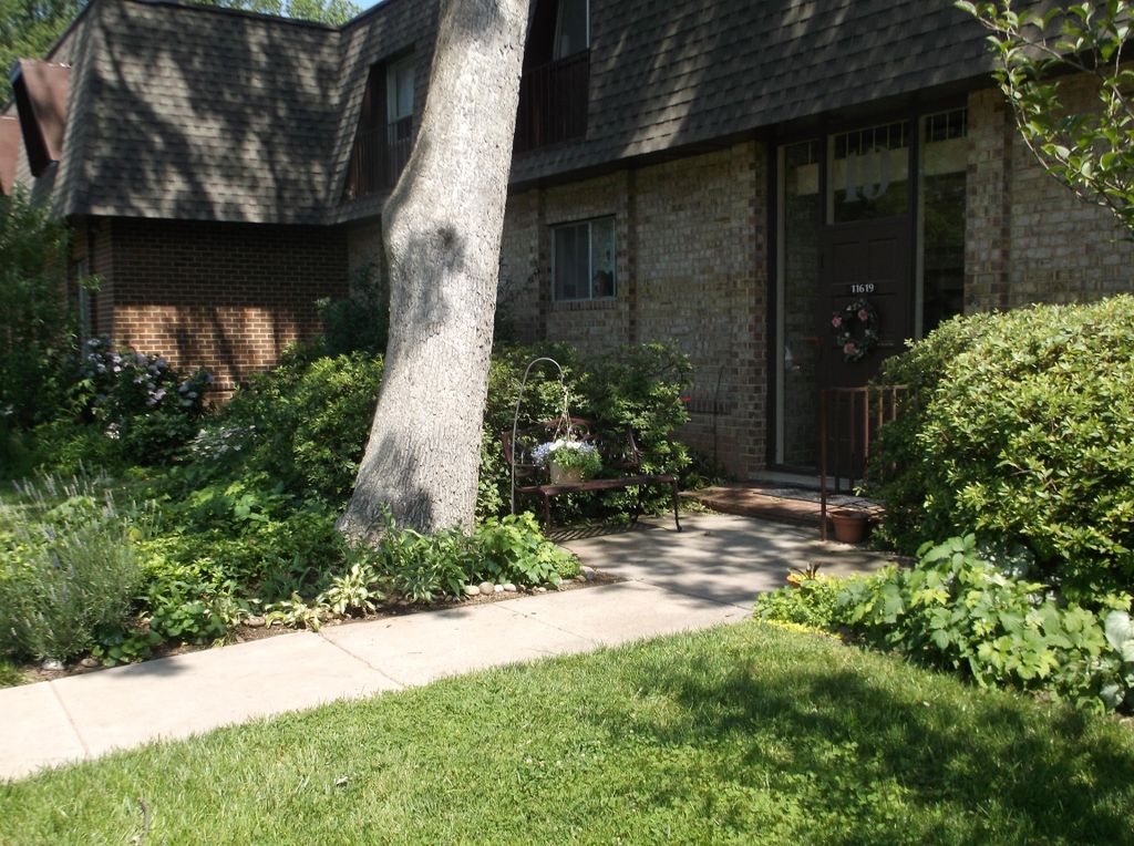 Front door and bench by the Oak tree and garden.