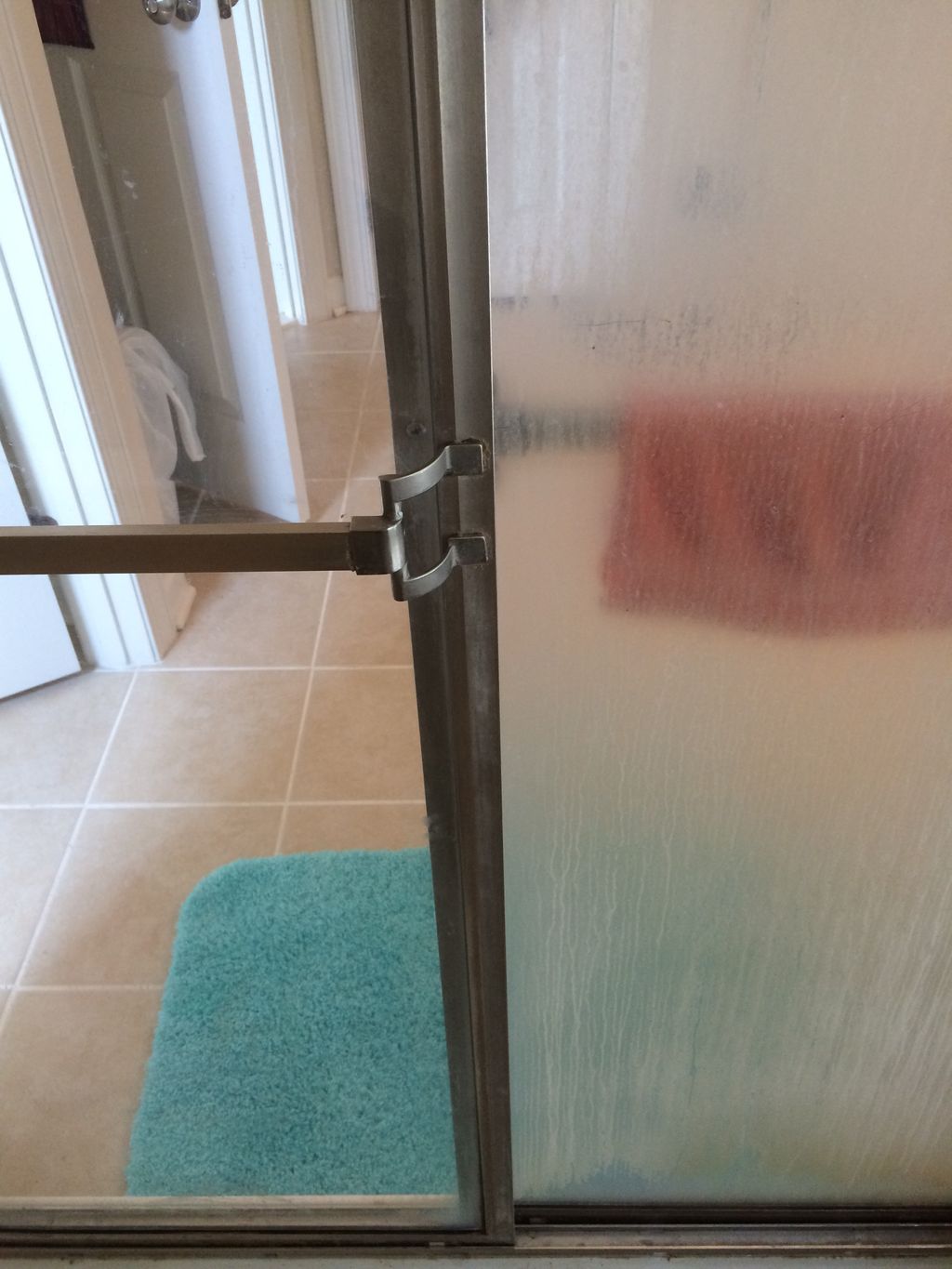 On the top, soap scum on a shower door, on the bot