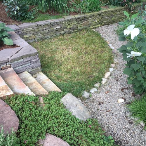 Sunken garden with dry stack wall, gravel path and