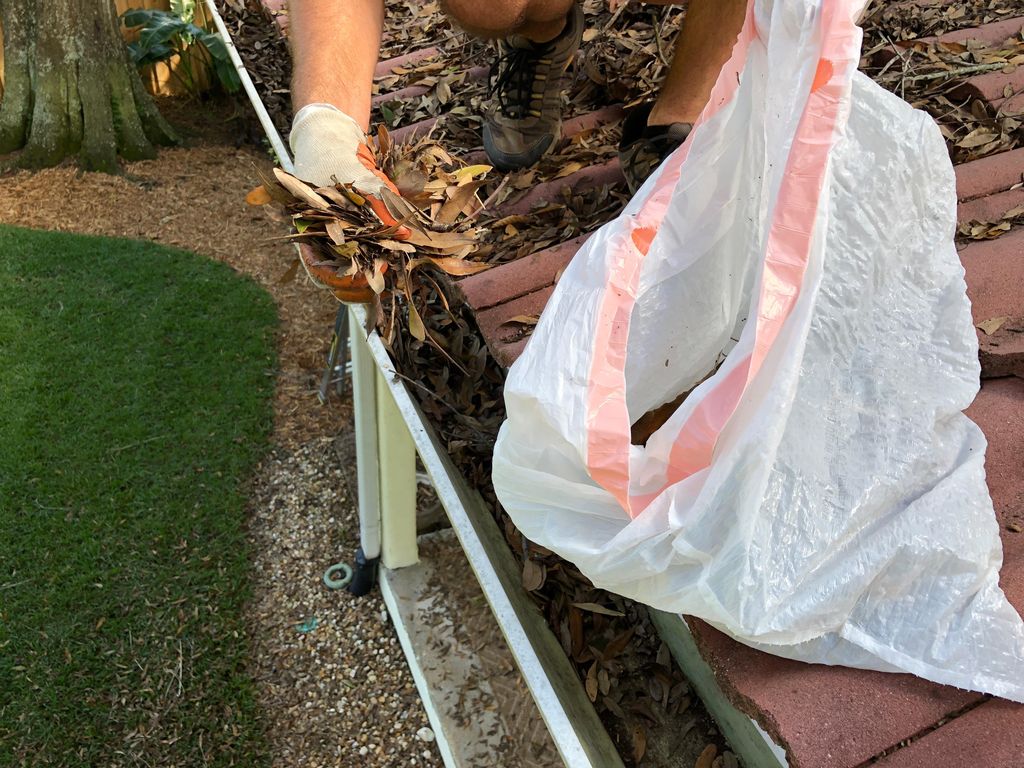 Hand Cleaning Gutters and Bagging the Trash