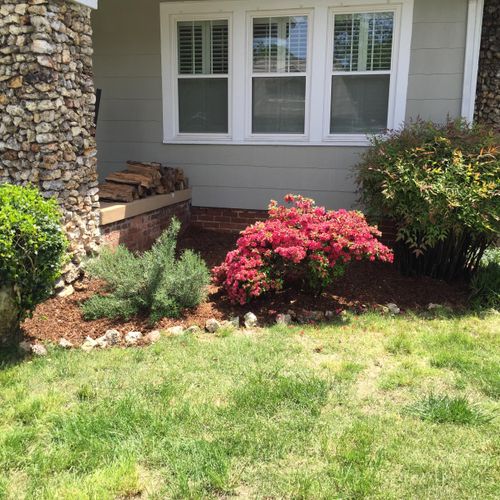 Trimmed bushes, new mulch, and clean edging.