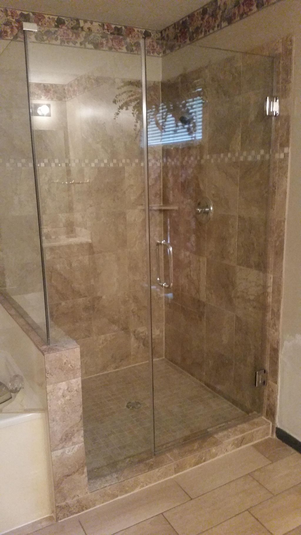 Ceramic wall tile with 2" border. Frameless shower